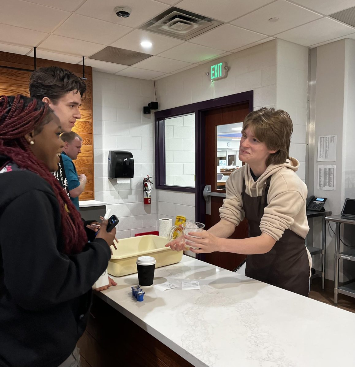 Senior Wyatt Caves handing a coffee to Senior Jael Davis in South’s coffee shop