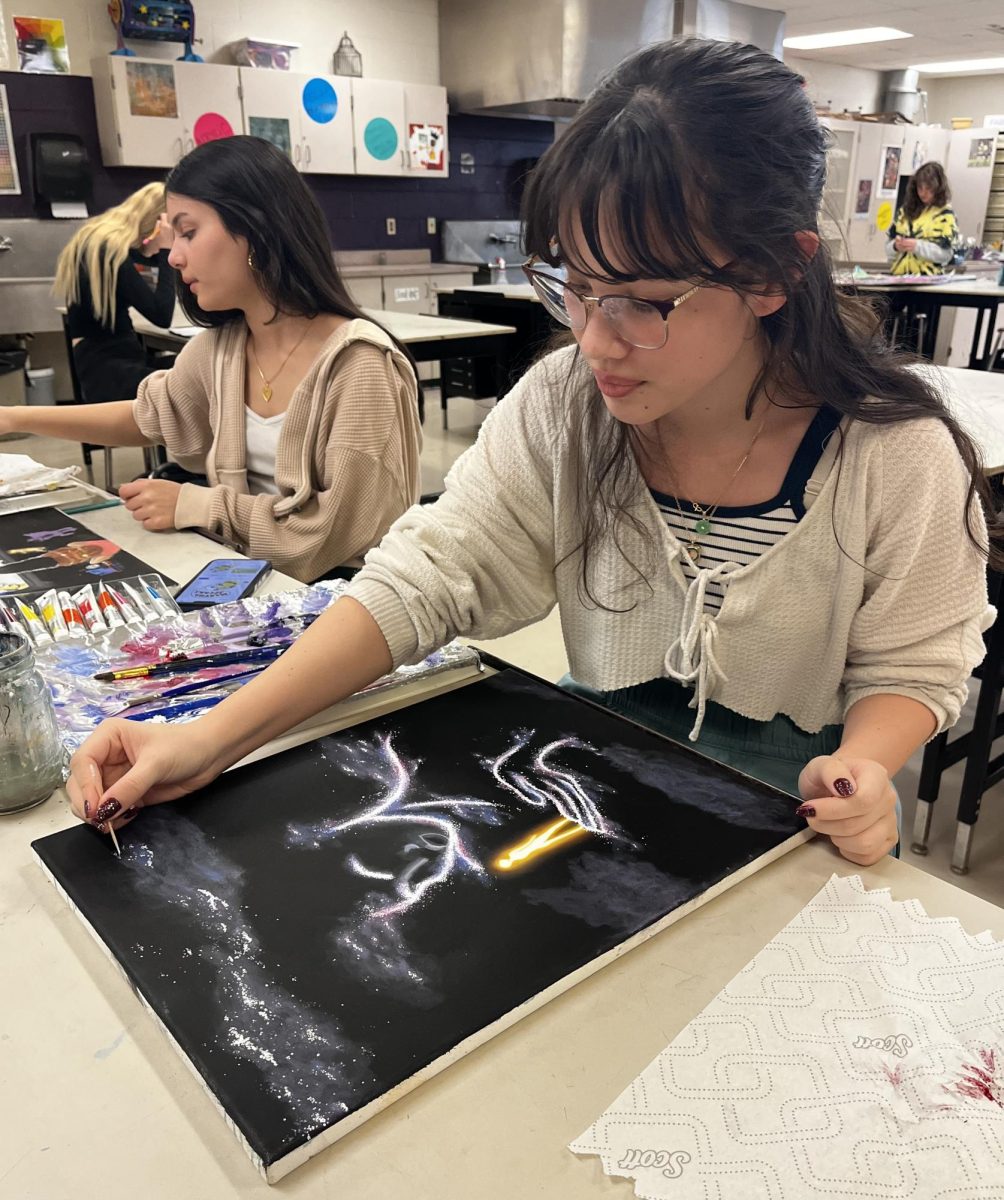 Senior Audrey Adams paints a picture for art class